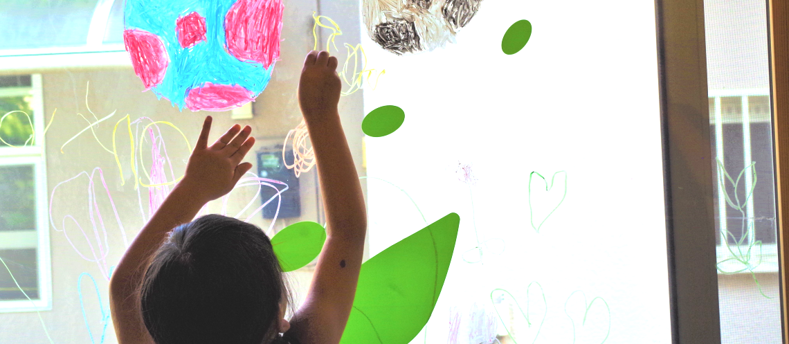 絵画造形教室アトリエ木のね　窓に自由にクレヨンで絵を描く女の子